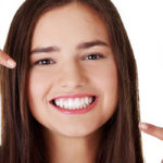 Teenage Girl Pointing At Her Beautiful Teeth