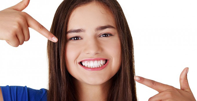 Teenage Girl Pointing At Her Beautiful Teeth