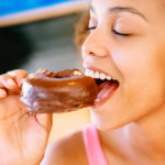 Girl Eating a Donut - Preventive Dentistry Helps Prevent Cavities