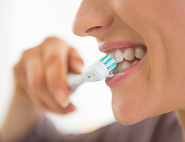 Teen Brushing Teeth With Electric Toothbrush