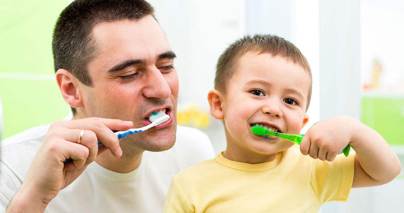 Father and Son Having Fun Brushing Teeth